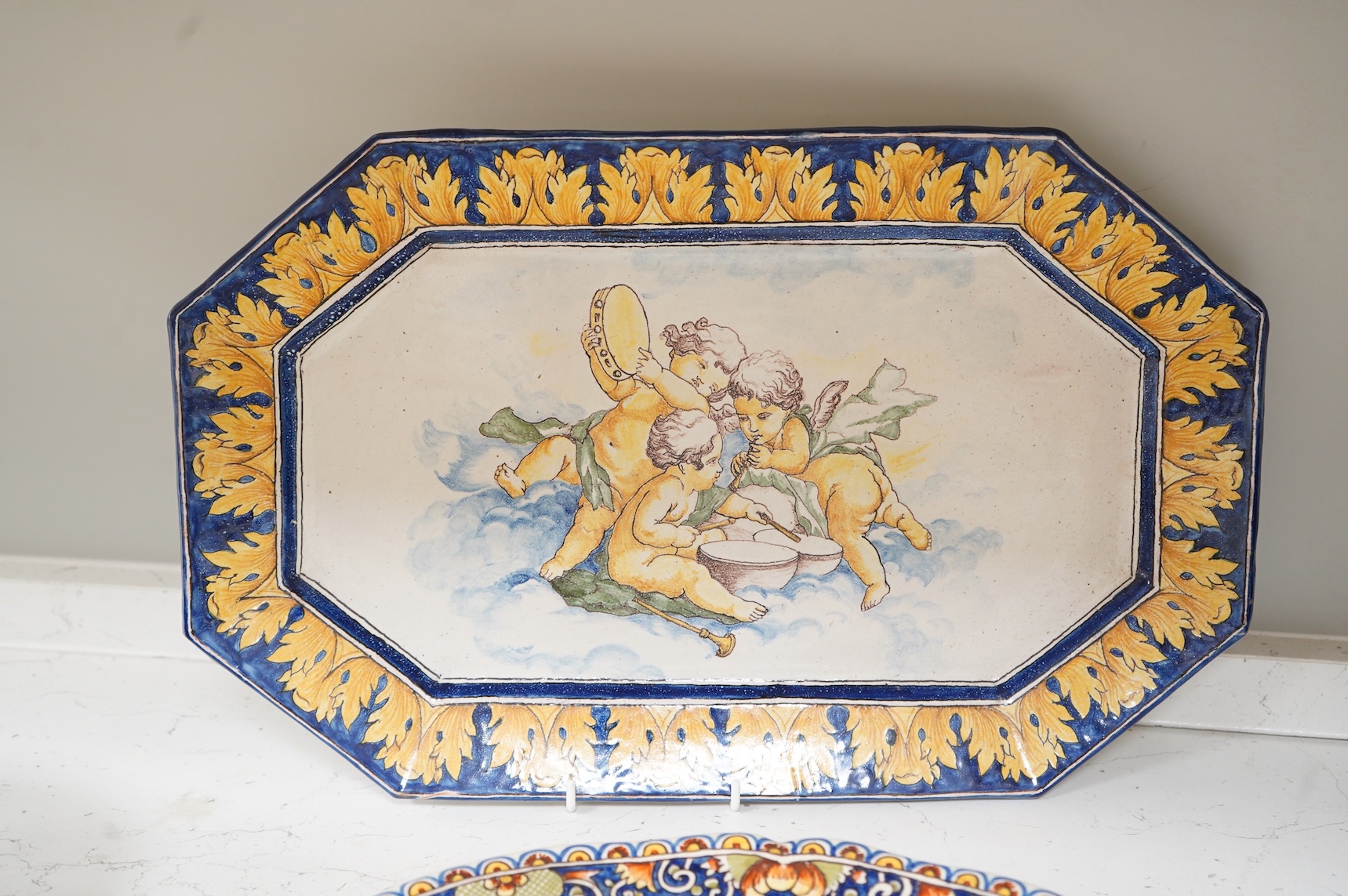 Four various late 19th century French faience dishes/stands, including a Nevers canted rectangular meat dish, largest 46cm wide